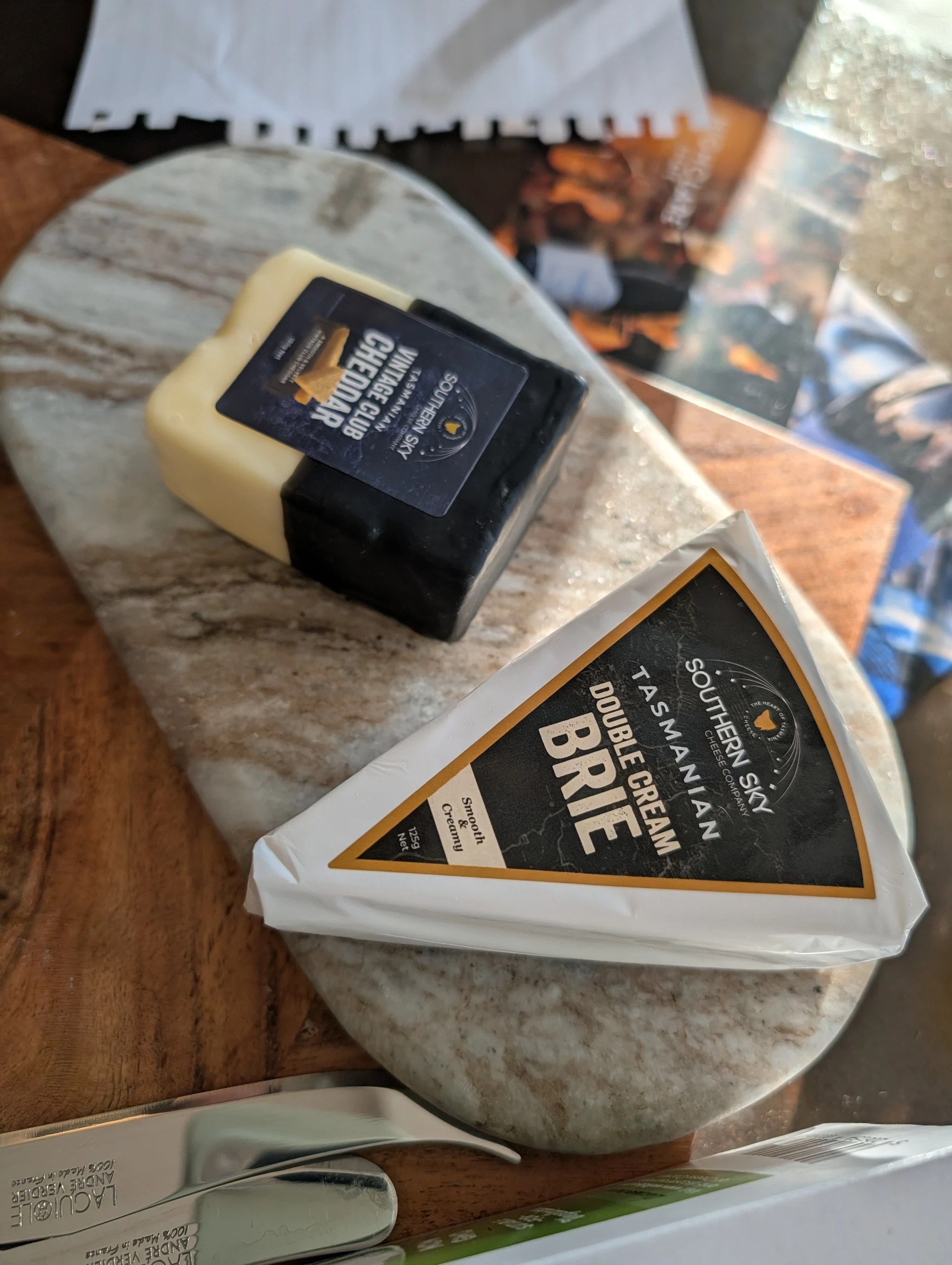 Tasmanian brie and vintage cheddar on marble platter.