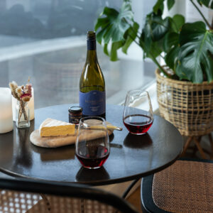 Red wine, cheese and jam on table